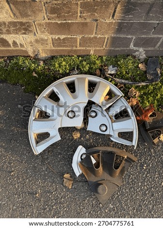 Broken Silver Hubcap On Side Of Footpath