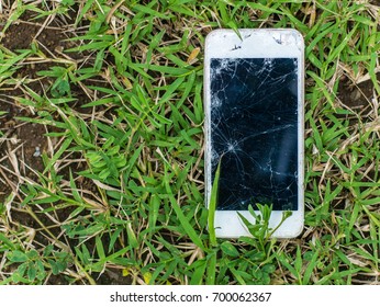 Broken smart phone on grass