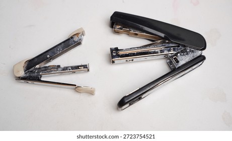 A broken stapler with a broken staple.