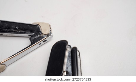 A broken stapler with a broken staple.