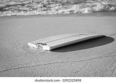 A Broken Surfboard At The Beach