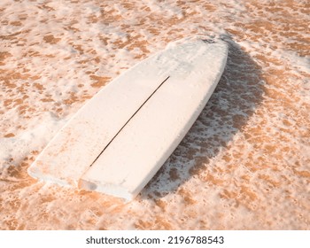 A Broken Surfboard At The Beach