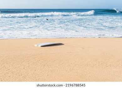 A Broken Surfboard At The Beach