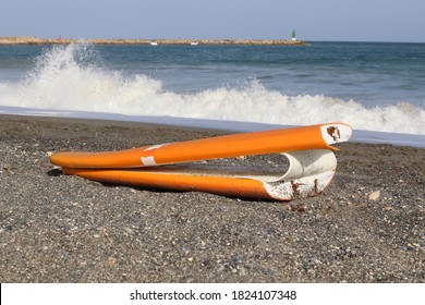 Broken Surfboard In The Sand