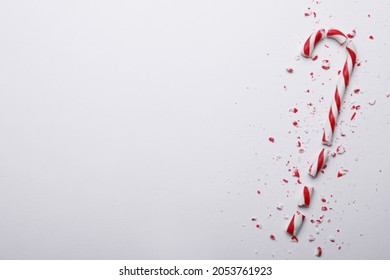 Broken sweet Christmas candy cane on white background, top view. Space for text - Powered by Shutterstock