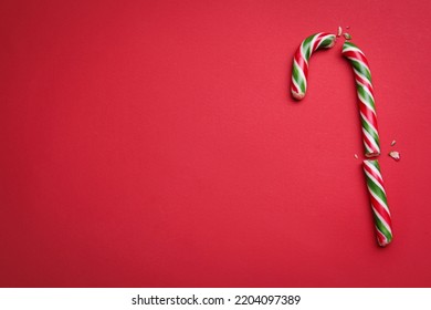 Broken sweet Christmas candy cane on red background, top view. Space for text - Powered by Shutterstock