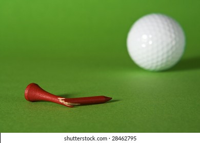 Broken Tee And Golf Ball On Green Background