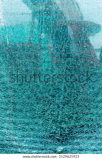 Broken\
tempered glass background. Broken tempered glass as an abstract\
background. Broken glass wall outdoor\
background.
