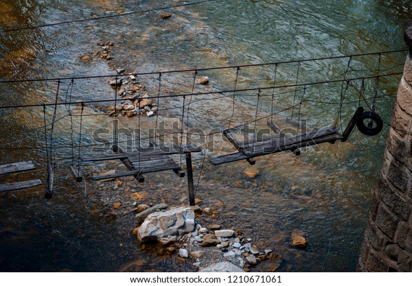 broken tension\
bridge on ropes over the\
river
