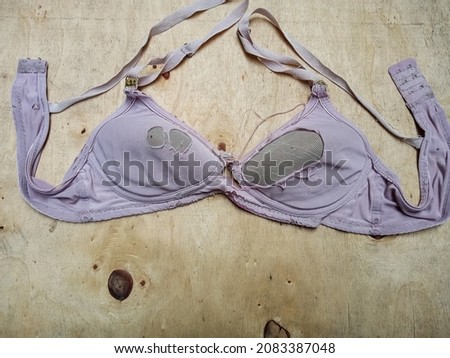 broken and torn bra on a wooden table