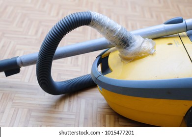 A Broken Vacuum Cleaner. Torn Hose Wrapped In Duct Tape.