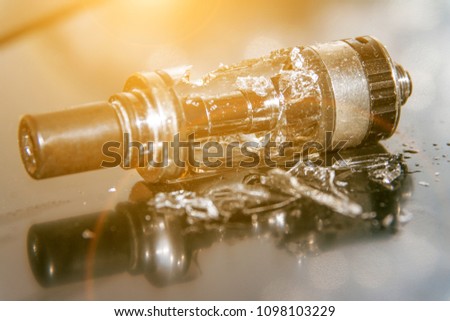 Broken vaping on the table with small pieces of glass. broken glass tank