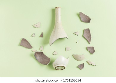 A broken vase against a green background