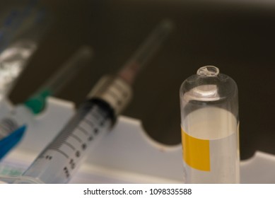 Broken Vial Of Anesthetic Drug After Use In Operating Room And Syringes On Background
