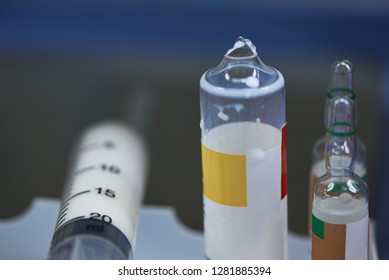 Broken Vial Of Anesthetic Drug After Use In Operating Room And A Plastic Syringe With White Medication