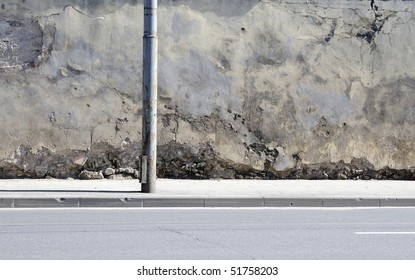 The Broken Wall Near To Road. Street In Old City. Column. Early Evening