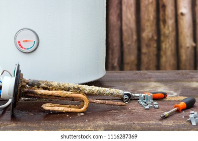 Broken Water Heater With Heating Elements, On Wooden Background.