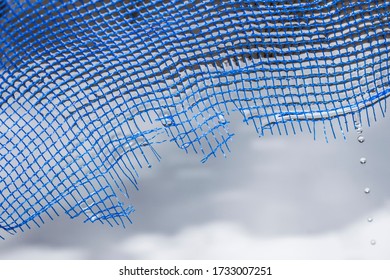 Broken And Wet Blue Fishing Net.