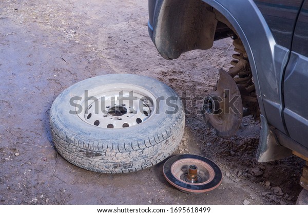 A broken wheel lies next to the car.\
Breakdown on the road. Urgent car\
repair.