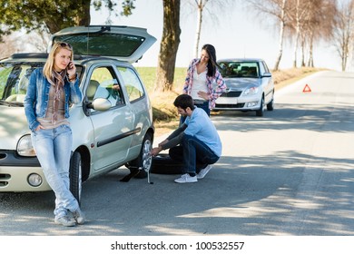 Broken wheel man changing tire help two female friends
