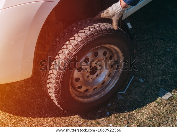 Broken wheel on the road. Replacement wheels on the\
road with their own\
hands
