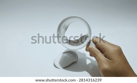 A broken white ceramic mug is shown with its handle still intact, isolated on a white background.