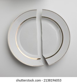 Broken White Porcelain Plate On A White Background. Concept Lack Of Food