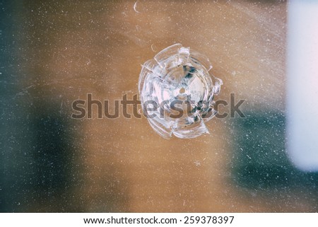 broken window with a bullet hole.