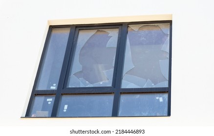 Broken window of a residential building, sharp pieces of glass sticking out. Fighting in Ukraine, the destruction of buildings from bombing and rocket attacks by a blast wave