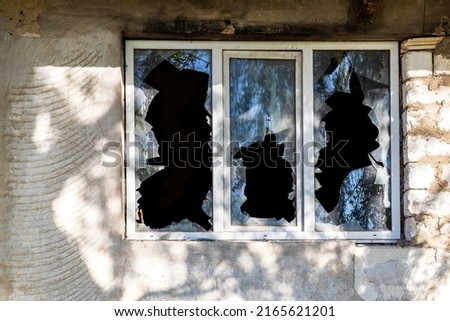 Broken window of residential home in close-up. Broken glass window outside .