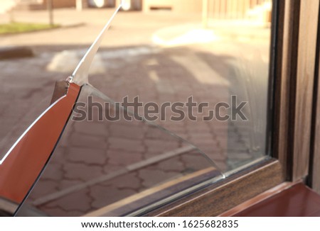 Broken window with sharp smithereens outdoors. Requiring repair
