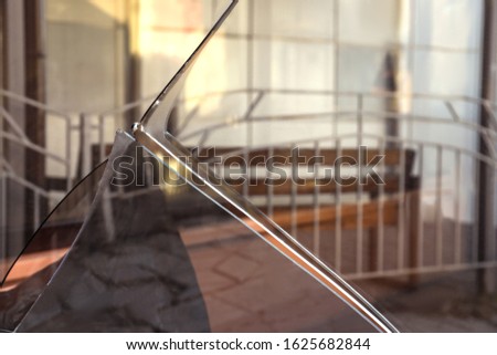 Broken window with sharp smithereens outdoors. Requiring repair