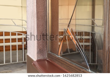 Broken window with sharp smithereens outdoors. Requiring repair