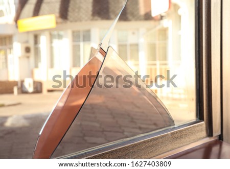 Broken window with sharp smithereens outdoors. Requiring repair