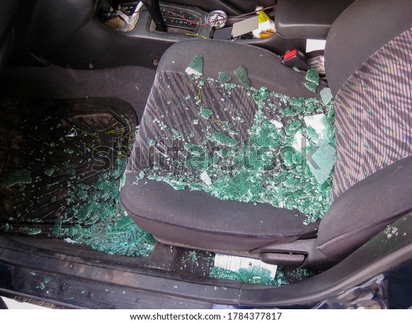 A\
broken window with splinters scattered across the interior of the\
car during a road accident close-up. blurred\
focus