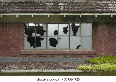 Broken windows in an old abandoned brick building