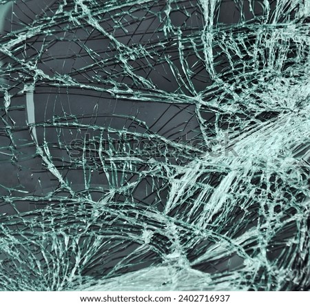 Broken windscreen of car during riots, street skirmishes. glass pieces hole looks mayhem