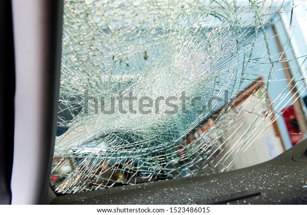Broken Windscreen or crack windshield of\
a car in auto service station garage. Broken car windshield,\
damaged glass. Accident of car. Selective\
focus