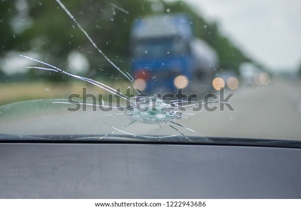 飛ぶ石で車のフロントガラスが壊れた ガラスの穴 切れ目 破片 細長い割れ目 鏡が雲で空を反射する の写真素材 今すぐ編集