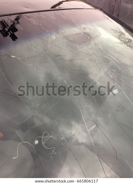 Broken windshield from hail\
damage