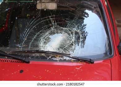 Broken Windshield On Car. Traffic Accident With Crash Glass On Vehicle. Strong Impact On Automobile. Car Damaged Consequences After Heavy Storm.