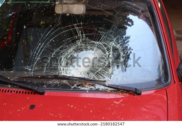 Broken windshield on car. Traffic accident with\
crash glass on vehicle. Strong impact on automobile. Car damaged\
consequences after heavy\
storm.