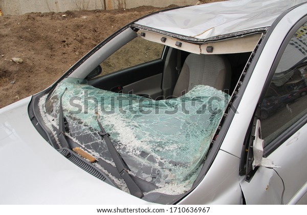 Broken windshield. A broken\
silver car after an accident on the road. Transport security\
concept.