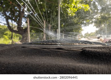 Broken windshield from stone impact viewed from inside car