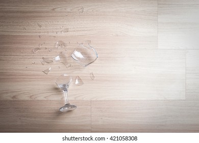 Broken Wine Glass On Wooden Floor