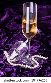 Broken Wineglass Near The Full One With Pearl Necklace As Concept Of Loneliness