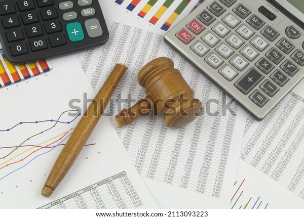 Broken wooden judge gavel and two\
calculators on financial data.  Law and arbitration\
concept	