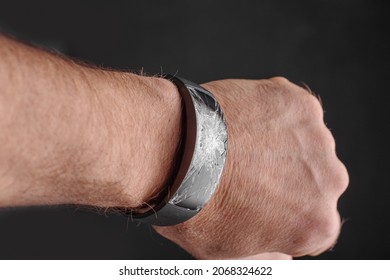 Broken wrist watch on mans wrist ,representing lost time concept.