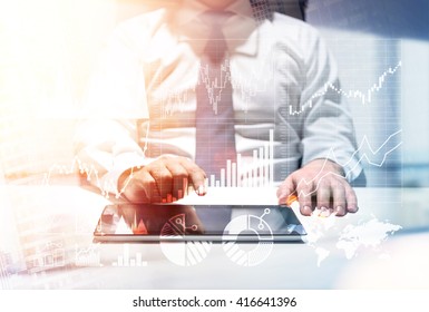 Broker Consultant With Charts Using Tablet At Office Desk To Make A Stock Exchange Deal. Double Exposure