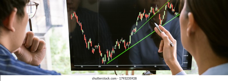broker showing some ascending to his colleague planning and analyzing graph stock market trading with stock chart data on multiple computer screens - Shutterstock ID 1793235928
